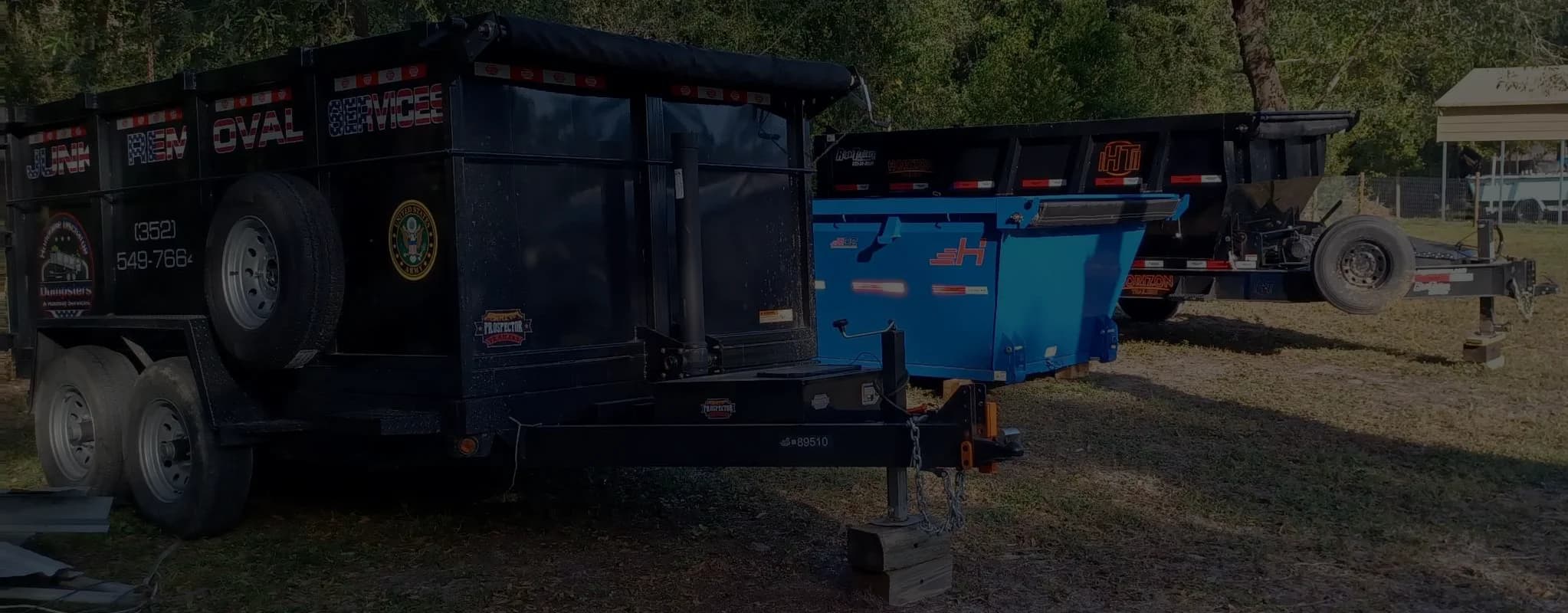 Three dumpsters lined up next to each other.