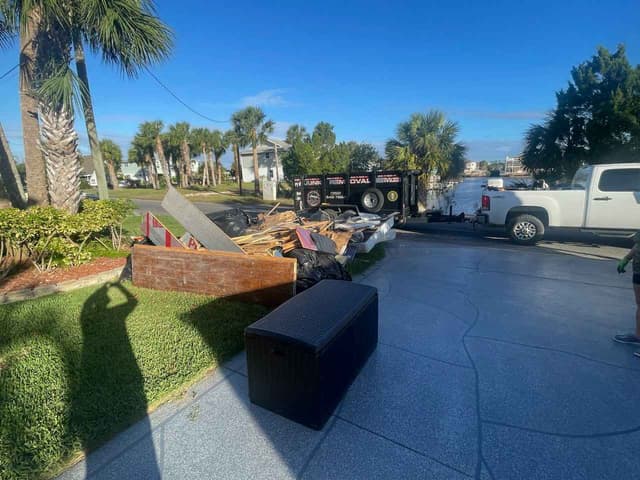 Dumpster being filled with branches and logs